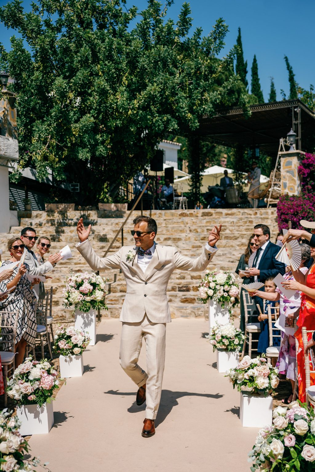 Groom walking down the aisle with his arms up, Casa de la Era wedding in Marbella