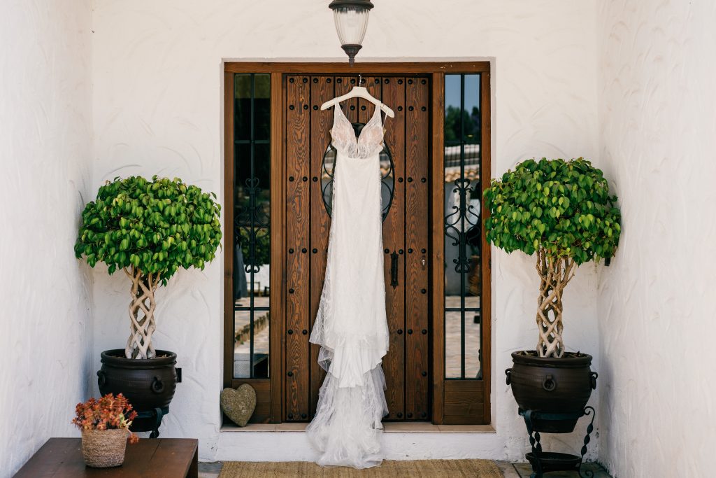 Wedding dress hanging on a wooden door, Casa de la Era wedding in Marbella