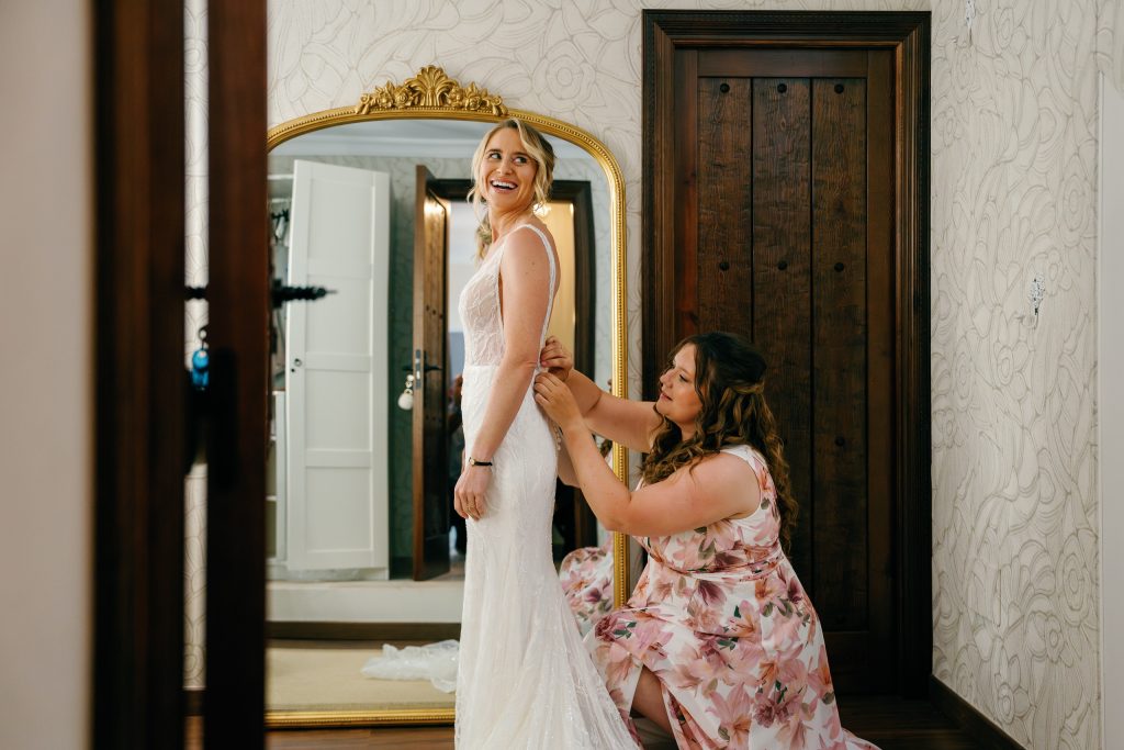 Bride getting help with her dress at the mirror, Casa de la Era wedding in Marbella