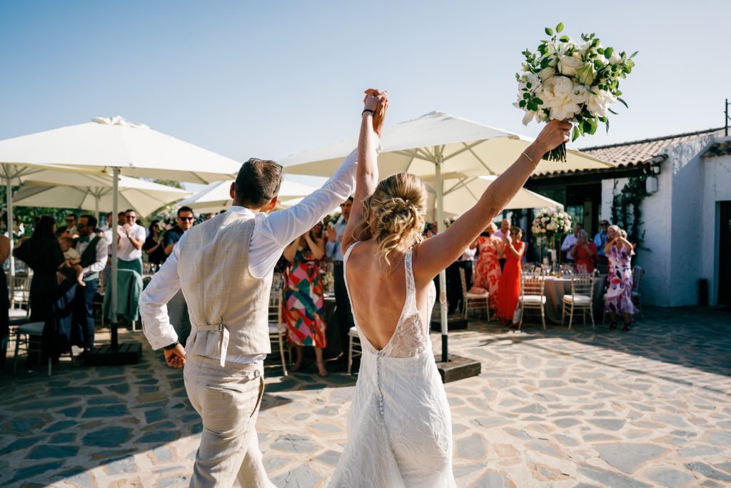 Couple entering the dinner with their arms up, Casa de la Era wedding in Marbella