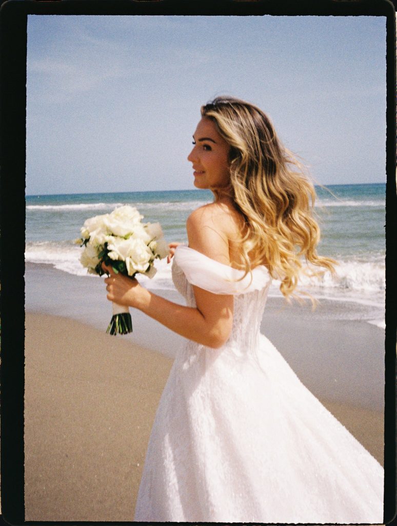 Bride with her bouquet turning on the beach, 35mm film wedding photo on the Costa del Sol