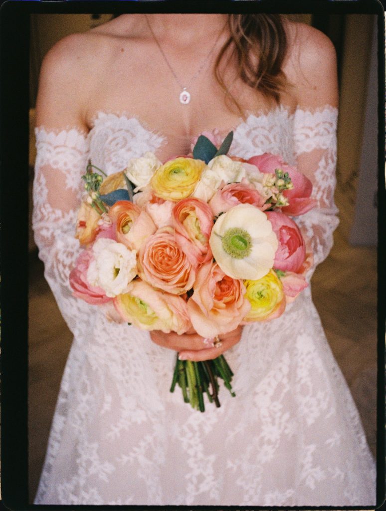 Bride holding a pastel bouquet of roses and ranunculus, 35mm film wedding photo on the Costa del Sol
