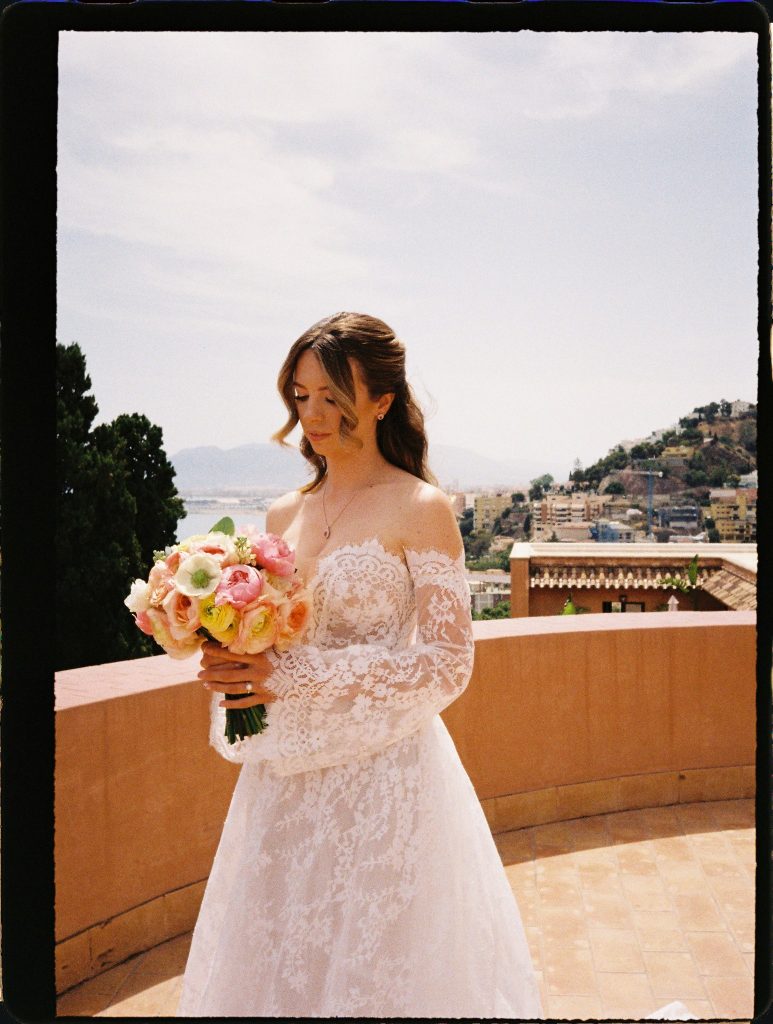 Bride with her bouquet on a terrace overlooking the coast, 35mm film wedding photo on the Costa del Sol