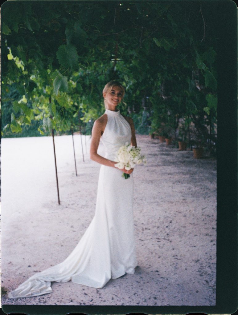 Bride in a halter dress under a vine pergola, 35mm film wedding photo on the Costa del Sol