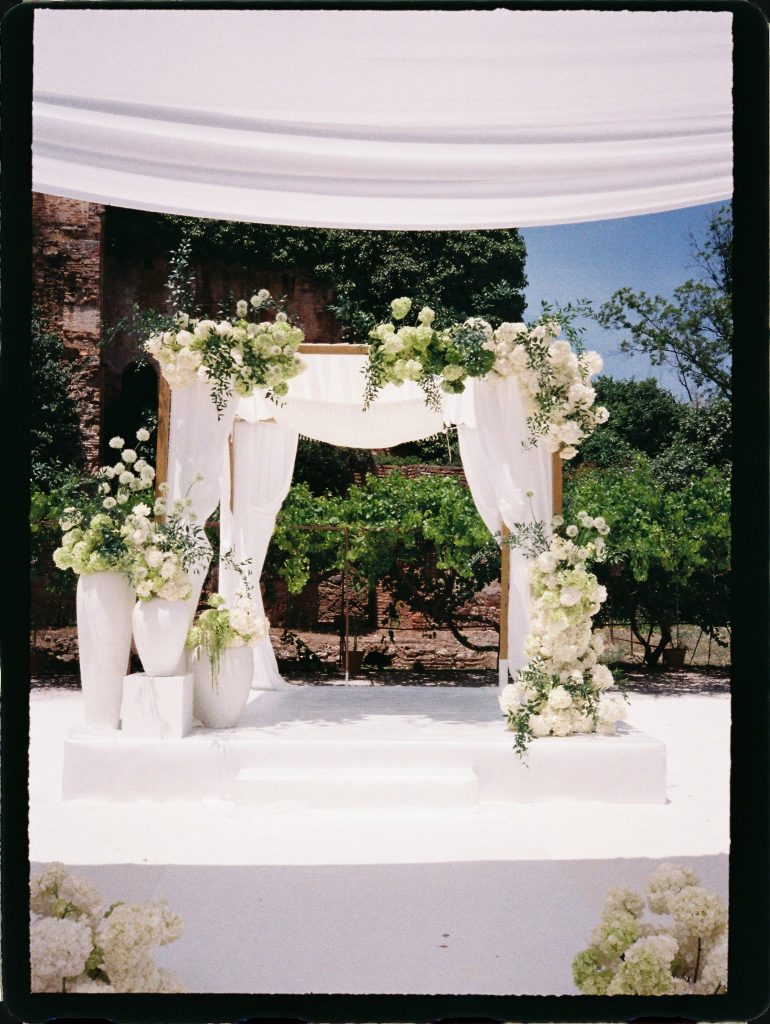 Wedding ceremony canopy with white flowers and draped fabric, 35mm film wedding photo on the Costa del Sol