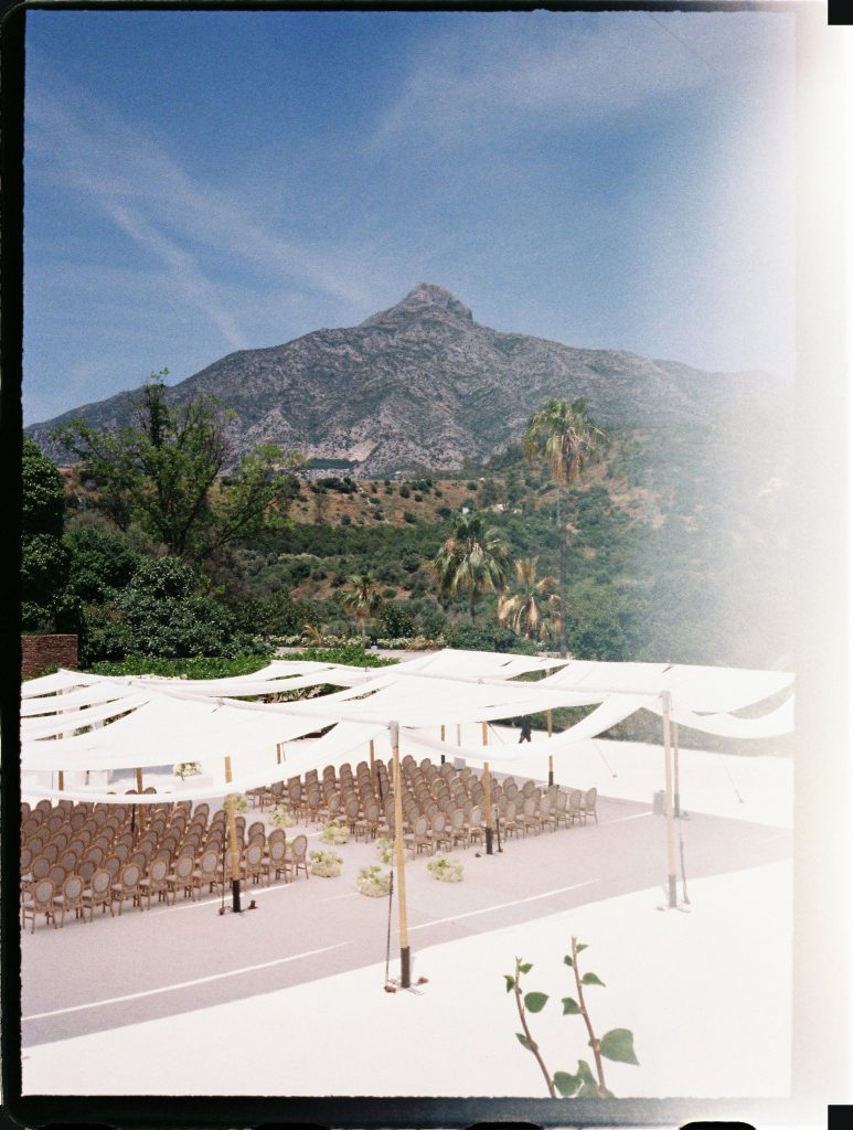Wedding ceremony set-up under white shades with the mountains behind, 35mm film wedding photo on the Costa del Sol