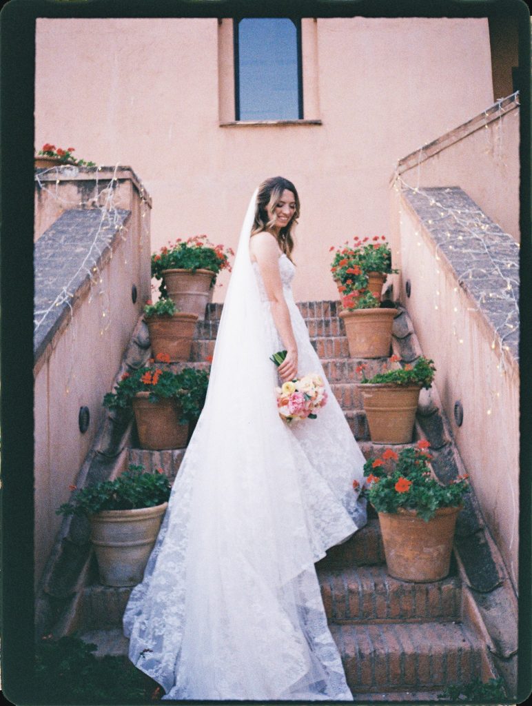 Bride on terracotta steps lined with flower pots, 35mm film wedding photo on the Costa del Sol