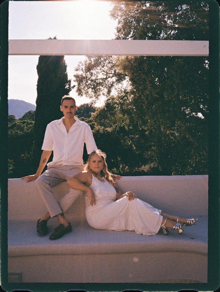 Couple relaxing on a white sofa under a pergola, 35mm film wedding photo on the Costa del Sol