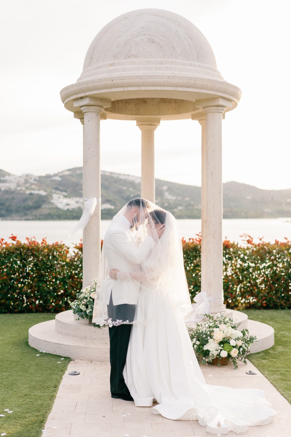Bride and groom hold hands during the ceremony under the white pavilion, Hotel La Viñuela wedding near Nerja
